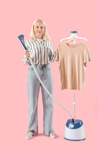 Happy starší žena s moderním oděvem parník a tričko na růžovém pozadí - Fotografie, Obrázek
