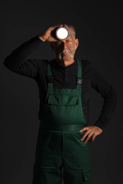Ώριμος άνθρωπος ανθρακωρύχος με προβολέα σε σκούρο φόντο - Φωτογραφία, εικόνα