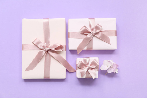 Cajas de regalo y hermosas flores de hortensias sobre fondo lila. Día Internacional de la Mujer - Foto, Imagen