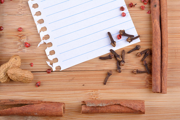 Paper sheet with spices on wood - Zdjęcie, obraz
