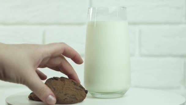 Hand taucht einen Keks in ein Glas Milch - Filmmaterial, Video
