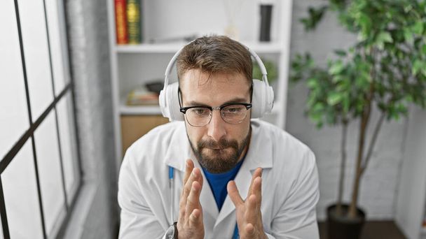 Joven médico hispano escuchando música en la clínica - Foto, imagen