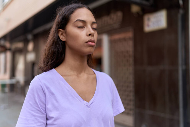 Молода афроамериканка дихає закритими очима на вулиці - Фото, зображення