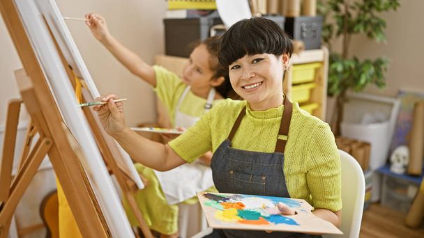 Selbstbewusster Kunstlehrer und Schüler malen fröhlich zusammen, im gemütlichen Inneren des Kunstateliers blüht das Lächeln. - Foto, Bild