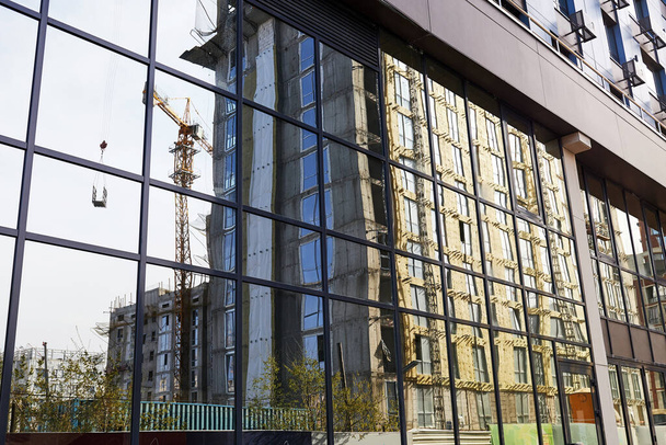 façade en miroir du bâtiment avec reflet du bâtiment en construction - Photo, image