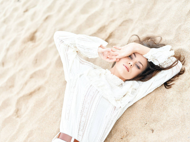Letní krása: Mladá žena u pláže, těší slunce a moře, portrét v bílých šatech - Fotografie, Obrázek