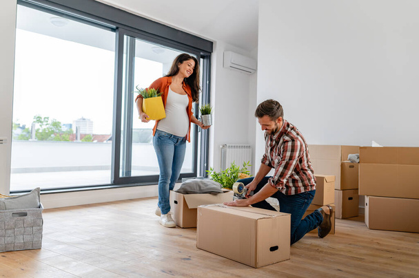 fiatal férfi és nő dobozokkal az új otthonban - Fotó, kép