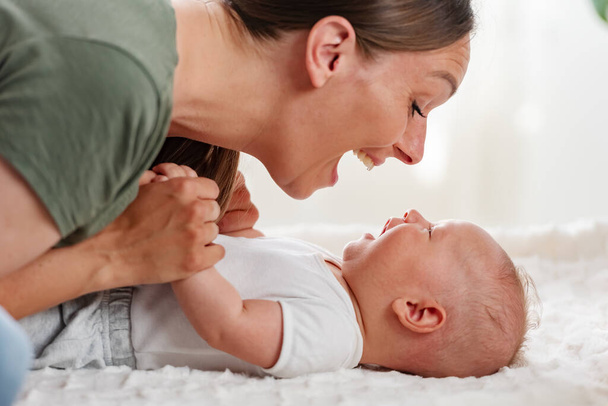 mother playing with a newborn baby at home - Photo, Image