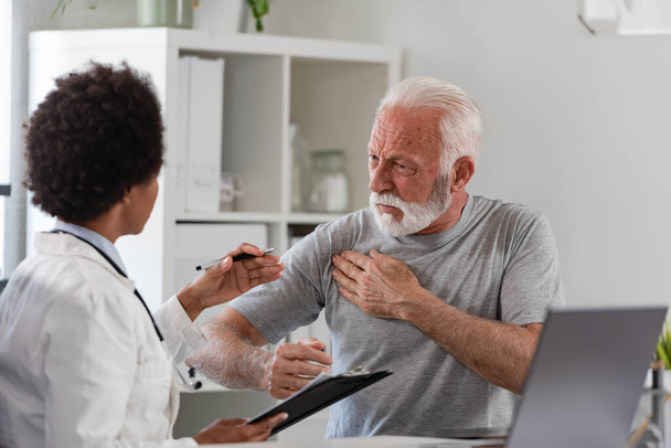 african american woman doctor examining senior patient - Photo, Image