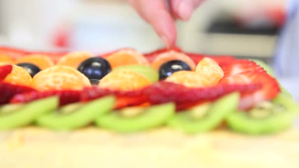 Ręce cukiernik, który przygotowuje ciasto owocowe - Materiał filmowy, wideo