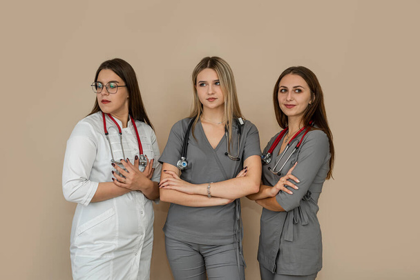 Équipe médicale avec trois femmes médecins debout ensemble sur fond isolé. Santé, concept de médecine - Photo, image
