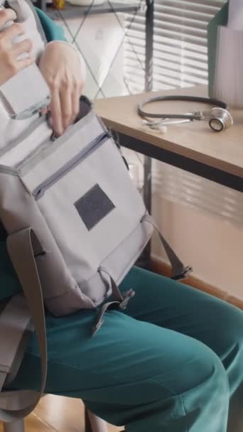 Вертикальный снимок сумки молодого азиатского врача перед отъездом домой после смены в клинику - Кадры, видео
