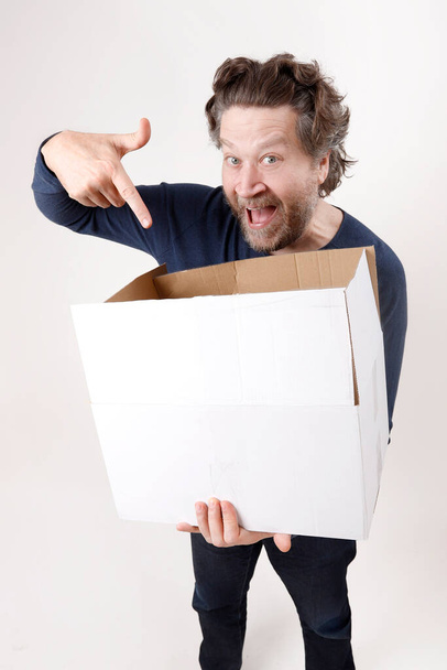 щасливий чоловік вказує на коробку, яку він отримав.studio shoot - Фото, зображення