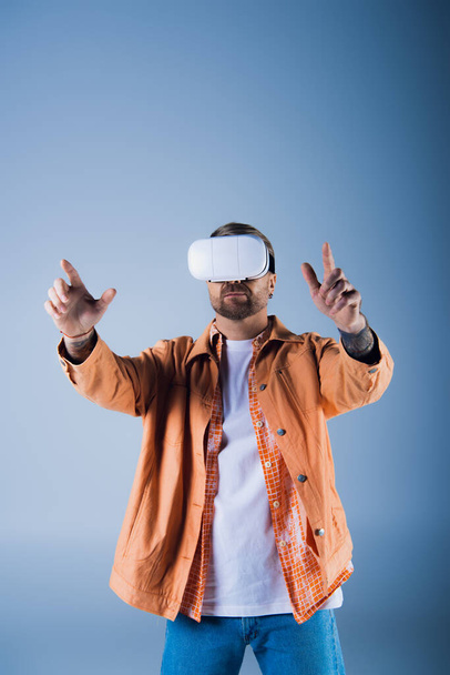 Ένας άνθρωπος που φοράει ακουστικά εικονικής πραγματικότητας σε ένα σκηνικό στούντιο, εξερευνώντας τον ψηφιακό κόσμο του Metaverse. - Φωτογραφία, εικόνα