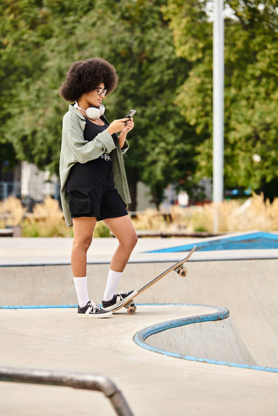 Молодая афроамериканка с кудрявыми волосами скейтбордистка, выполняющая трюки в ярком скейт-парке - Фото, изображение