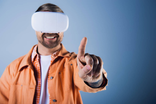 Um homem em um fone de ouvido VR fica com uma venda apontando diretamente para a câmera, incorporando uma perspectiva única. - Foto, Imagem