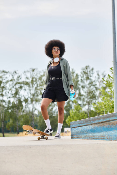 A young African American woman with an afro skillfully skateboards at a vibrant outdoor skate park. - Photo, Image