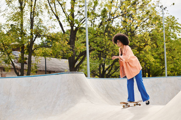 Молодая афроамериканка с вьющимися волосами умело катается на скейтборде в ярком скейт-парке. - Фото, изображение