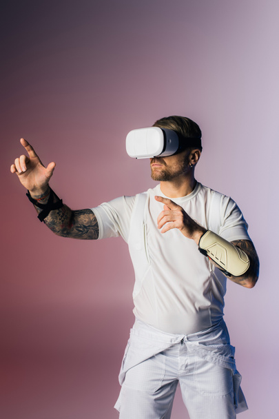 Человек в VR гарнитуре, одетый в белую рубашку и белые шорты, исследует метавселенную в студии. - Фото, изображение
