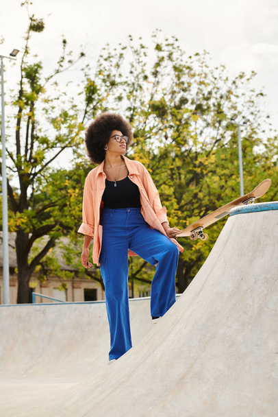 Junge Afroamerikanerin mit lockigem Haar skatet selbstbewusst in einem lebhaften Skatepark. - Foto, Bild
