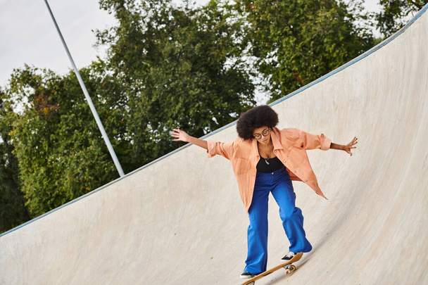 Молода афроамериканка з кучерявим волоссям катається на скейтборді в бік пандуса на відкритому скейт-парку. - Фото, зображення