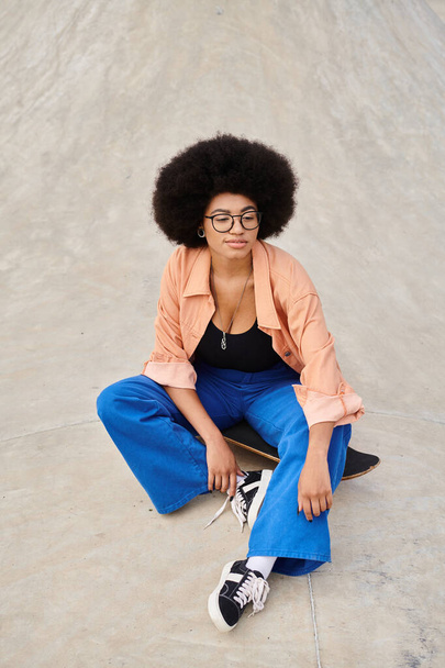 Nuori afroamerikkalainen nainen istuu skeittilaudalla eloisalla skeittilaudalla.. - Valokuva, kuva