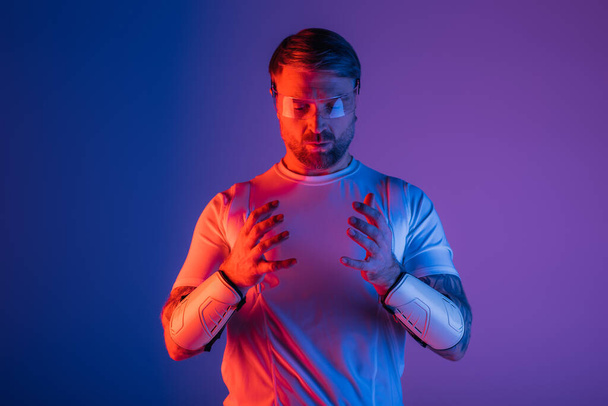 Ein Mann im weißen Hemd, die Hände ineinander verschlungen, strahlt Ruhe und Gelassenheit in einem Studio-Setting mit Virtual-Reality-Elementen aus. - Foto, Bild