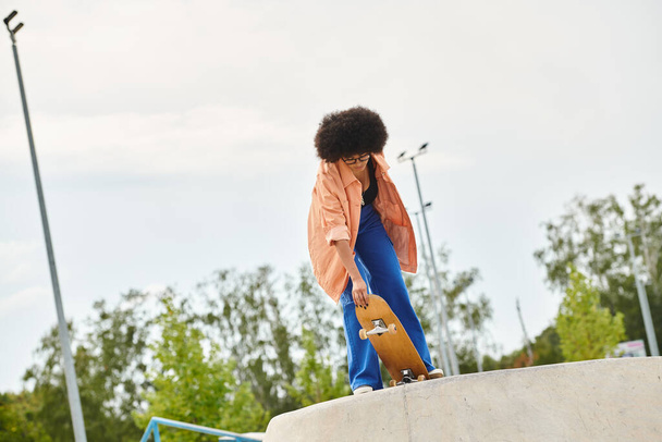 A young curly-haired woman full of daring energy, rides his skateboard up the steep side of a ramp in a dynamic display of skill and agility. - Photo, Image