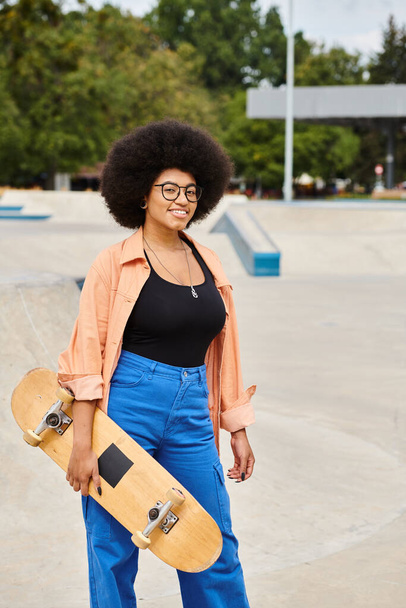 Een energieke jonge Afro-Amerikaanse vrouw houdt een skateboard vast terwijl ze omringd wordt door de stedelijke omgeving van een levendig skatepark.. - Foto, afbeelding