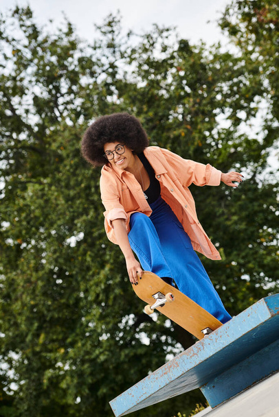 mujer negra se desliza sin esfuerzo por una rampa de skate con habilidad y precisión, mostrando movimiento audaz. - Foto, Imagen