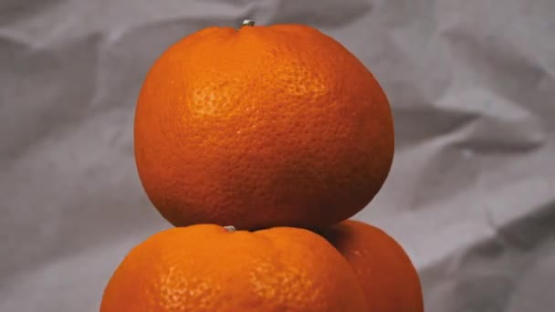 Disposizione artistica di tre arance fresche mette in mostra un trio di arance su uno sfondo rustico, mettendo in evidenza il loro colore vibrante e consistenza. - Filmati, video