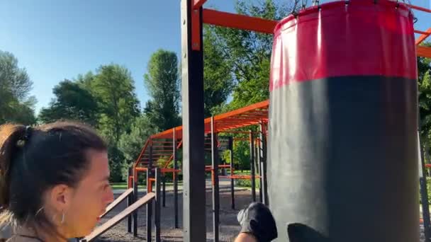 Ejercicio de actividad física en la zona de fitness al aire libre. Una joven adulta multiétnica se dedica al entrenamiento matutino en un parque público al amanecer. Fortaleza, flexibilidad, concepto de bienestar - Metraje, vídeo