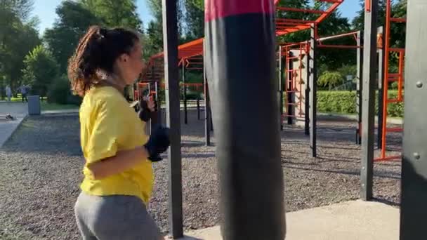 Fyzická aktivita cvičení ve venkovním fitness tréninkovém prostoru. Multietnická mladá dospělá žena se za úsvitu pouští do ranního cvičení ve veřejném parku. Síla, flexibilita, koncepce blahobytu - Záběry, video