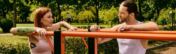 Un hombre y una mujer decididos en ropa deportiva están uno al lado del otro, motivados durante una sesión de entrenamiento al aire libre. - Foto, imagen