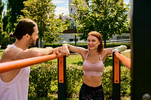 Ένας αποφασισμένος άνδρας και γυναίκα, στα αθλητικά, γυμνάζονται μαζί σε εξωτερικούς χώρους, επιδεικνύοντας κίνητρο και εστίαση. - Φωτογραφία, εικόνα
