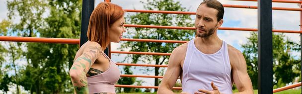 Een man en een vrouw in sportkleding oefening buiten, begeleid door hun persoonlijke programma, tonen vastberadenheid en motivatie. - Foto, afbeelding