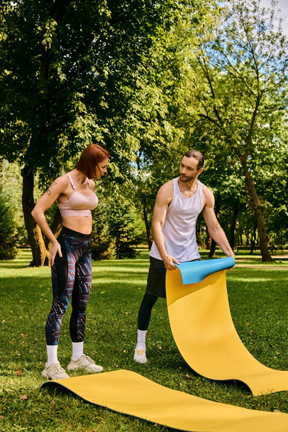 Un hombre y una mujer en ropa deportiva disfrutan de un momento lúdico en un tobogán en un parque, lleno de determinación y motivación. - Foto, Imagen