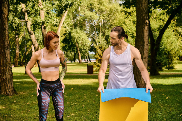 Η γυναίκα και ο προσωπικός της γυμναστής γυμνάζονται σε ένα πάρκο, επιδεικνύοντας αποφασιστικότητα και κίνητρο.. - Φωτογραφία, εικόνα