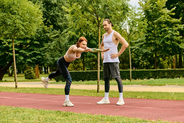 Чоловік і жінка, в спортивному одязі, фізичні вправи на траві, показують рішучість і мотивацію. - Фото, зображення