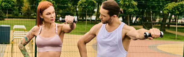 Чоловік і жінка, одягнені в спортивний одяг, беруть участь у тренуванні на яскравому тенісному корті. - Фото, зображення