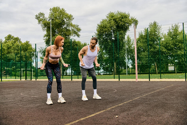 Twee atletische vrouwen in sportkleding staan vol vertrouwen op de top van een tennisbaan, met vastberadenheid en motivatie. - Foto, afbeelding