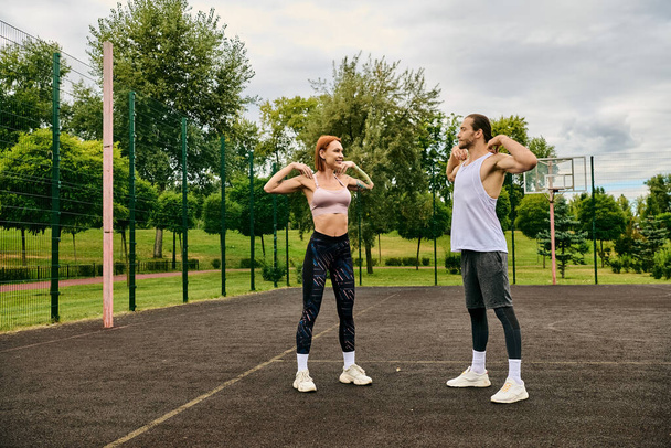 Een vrouw in sportkleding staat op een veld, traint samen met een personal trainer, toont vastberadenheid en motivatie. - Foto, afbeelding