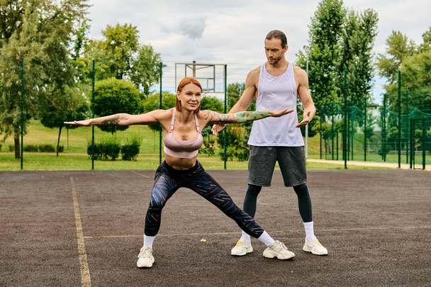 Mies ja nainen urheiluvaatteissa seisovat tenniskentällä keskittyen heidän koulutukseensa päättäväisesti ja motivoituneesti.. - Valokuva, kuva