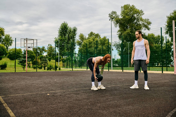 Een vrouw in sportkleding, begeleid door een personal trainer, toont vastberadenheid en motivatie op het veld. - Foto, afbeelding