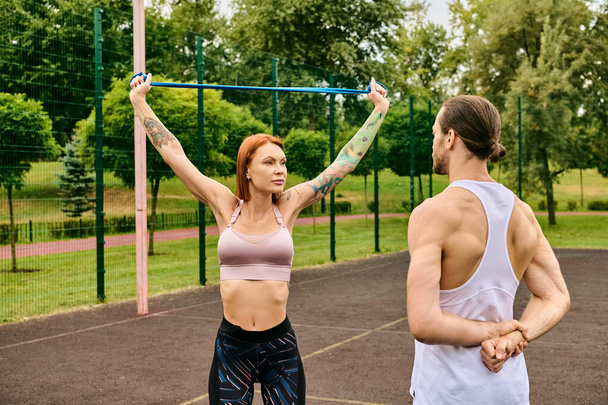 Чоловік і жінка, одягнені в спортивний одяг, тренуються разом на дворі - Фото, зображення