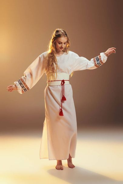 Egy fiatal mavka elegánsan díszíti a hagyományos fehér ruhát egy feltűnő piros bojttal, létrehozva egy mesebeli hangulatot egy stúdióban. - Fotó, kép