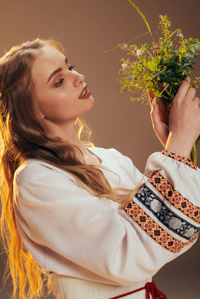 Eine junge Frau in einem weißen Kleid hält anmutig einen Blumenstrauß in einem zauberhaften Studio-Ambiente. - Foto, Bild