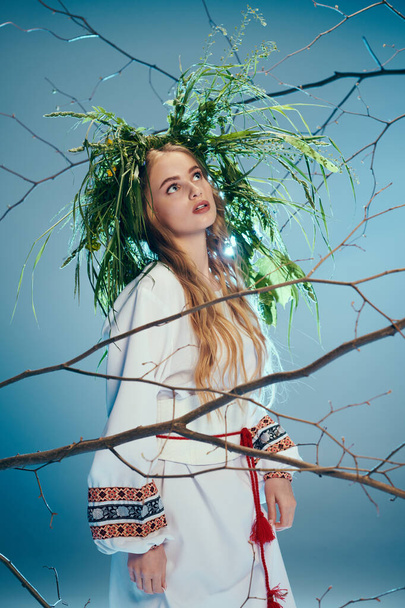 Uma jovem mavka fica graciosamente em frente a uma árvore, vestida com uma roupa tradicional com uma coroa de flores ornamentada na cabeça.. - Foto, Imagem