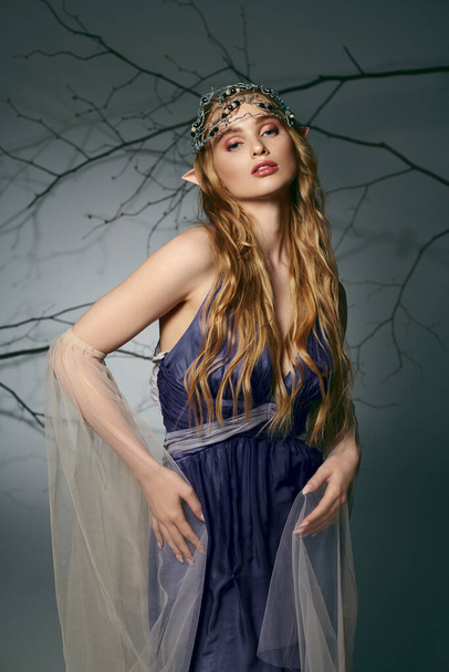 Una joven con un vestido azul se levanta elegantemente con un velo en la cabeza, exudando una sensación de fantasía y encanto. - Foto, Imagen
