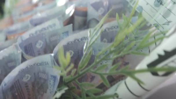 Para buketi. Mor on bin Endonezya rupiası, yeşil bir çiçek buketini andırarak benzersiz ve göz alıcı bir sergi yaratıyor. Kalimantan, Endonezya. 27 Kasım 2023 - Video, Çekim